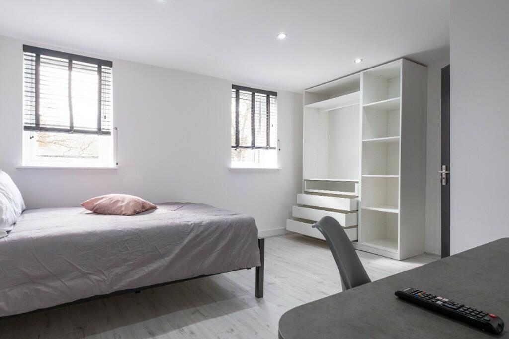 A bright and spacious double bedroom with moder...