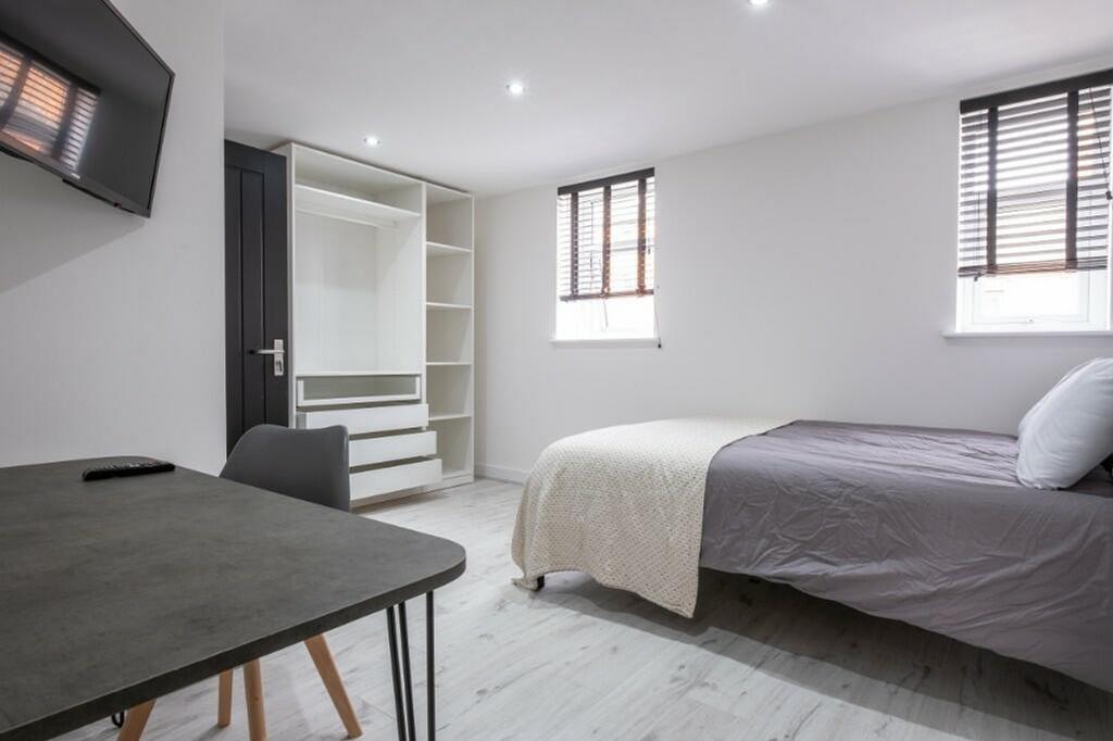 A spacious and well-lit double bedroom designed...