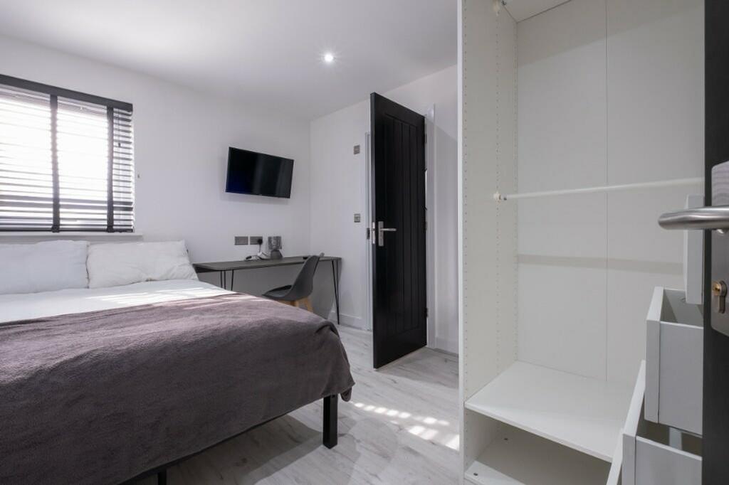 A modern and tidy double bedroom featuring ampl...