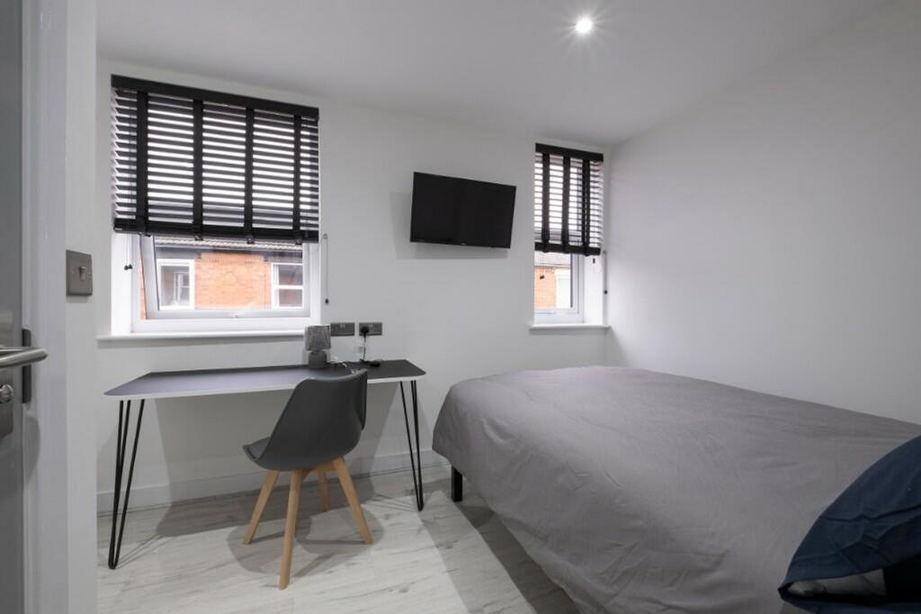 This stylish double bedroom features ample natu...
