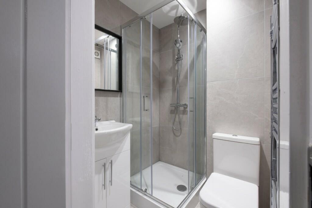 Modern bathroom suite featuring a sleek glass s...