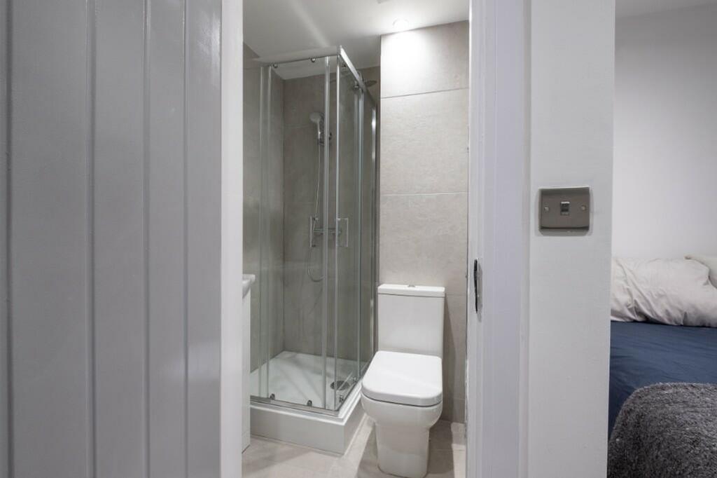 A modern bathroom featuring a spacious shower a...