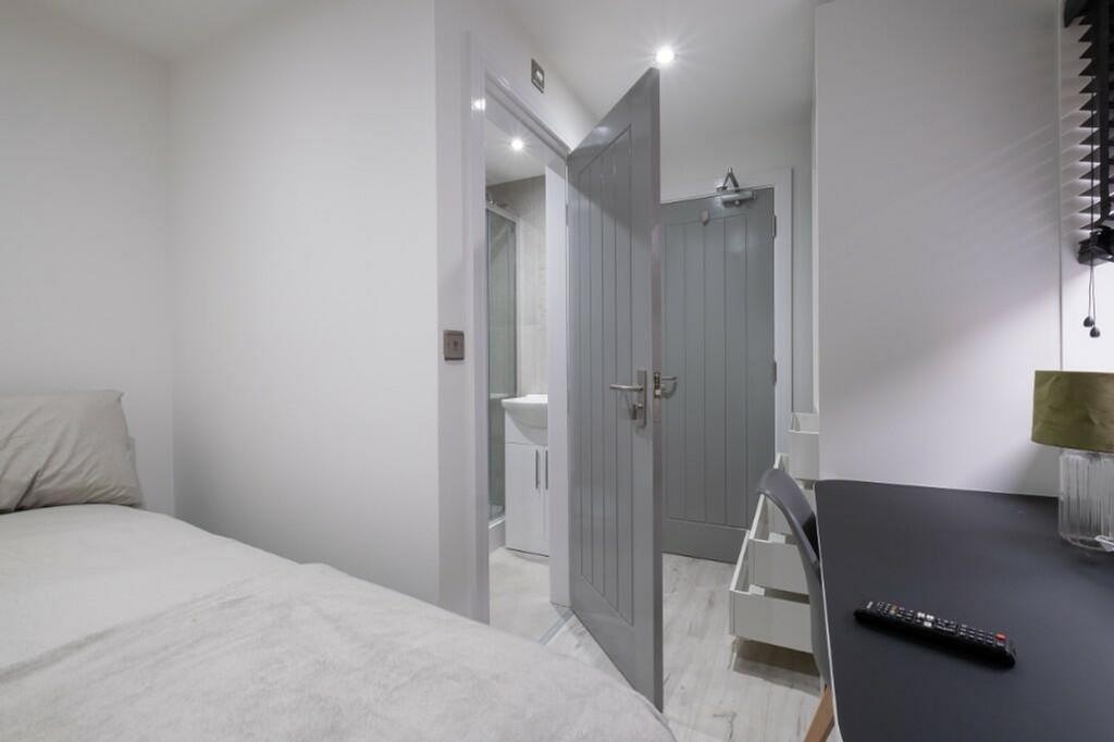 This inviting double bedroom features a cozy be...