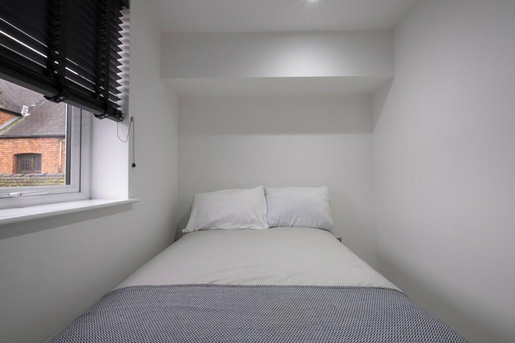 Cozy single bedroom featuring a comfortable bed...