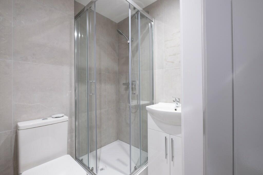 A modern bathroom featuring a sleek shower encl...