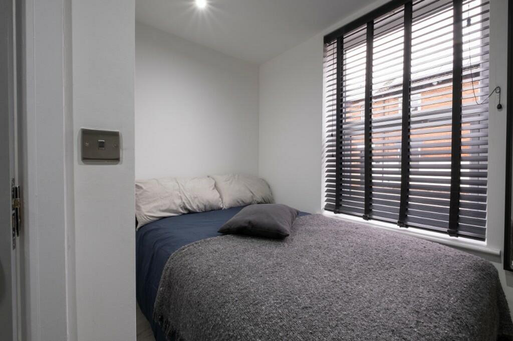 This cozy double bedroom features a comfortable...