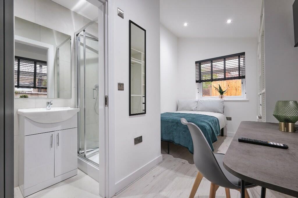 A modern and inviting double bedroom with an en...