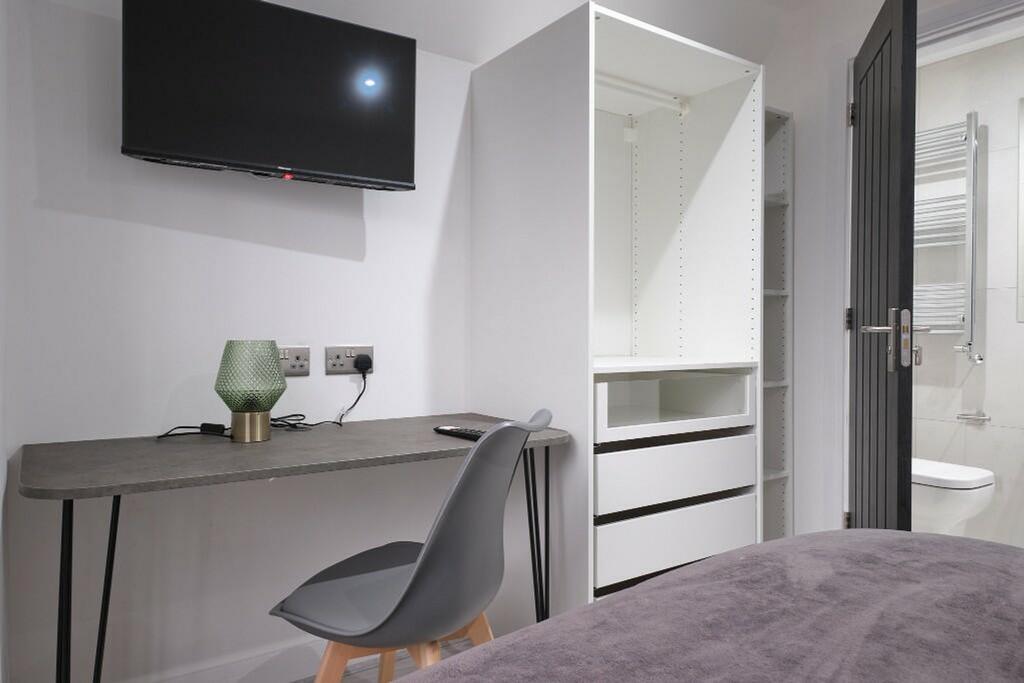 A modern and tidy double bedroom featuring a de...