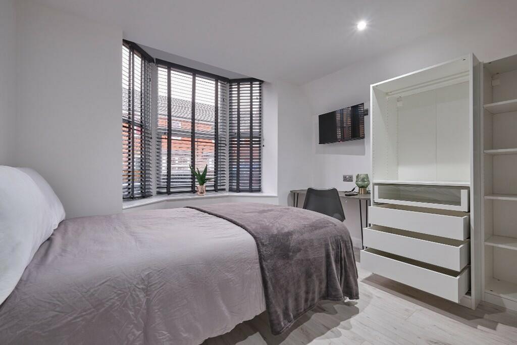 A bright and modern double bedroom featuring am...