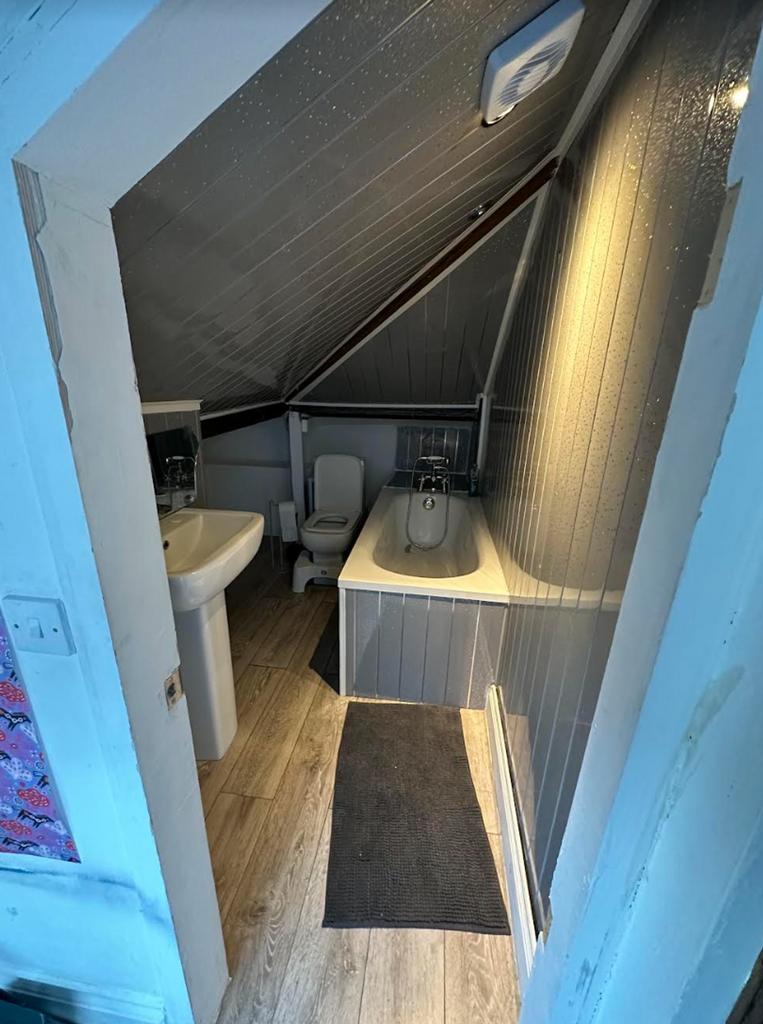 A bright and tidy bathroom featuring a bath, pe...