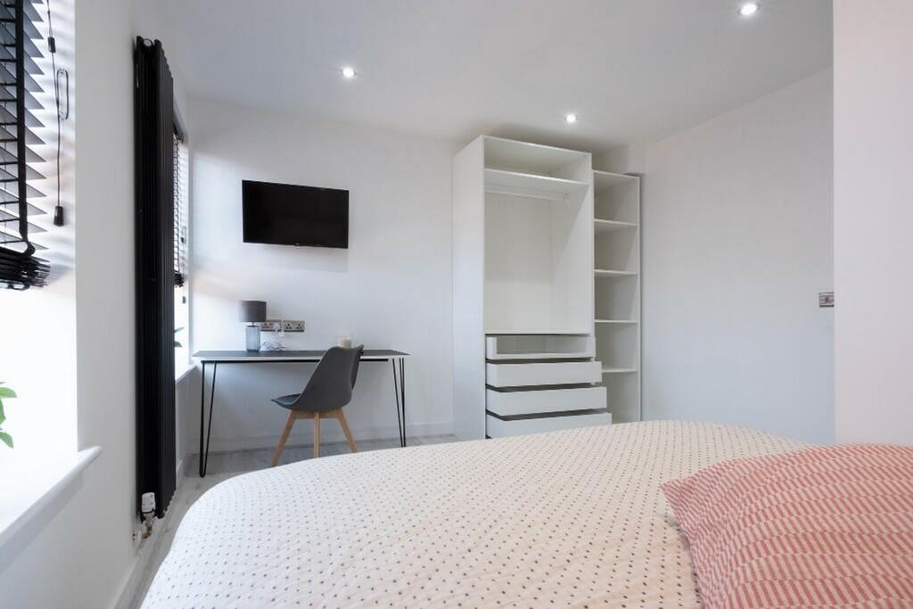 This stylish double bedroom features a cozy bed...