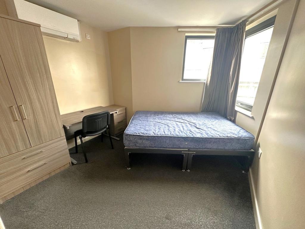 Bright, simply furnished bedroom with a single ...