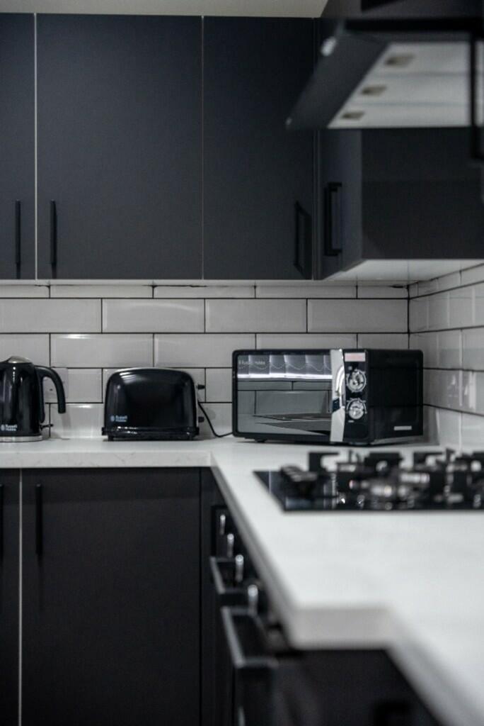 A modern and stylish kitchenette featuring slee...