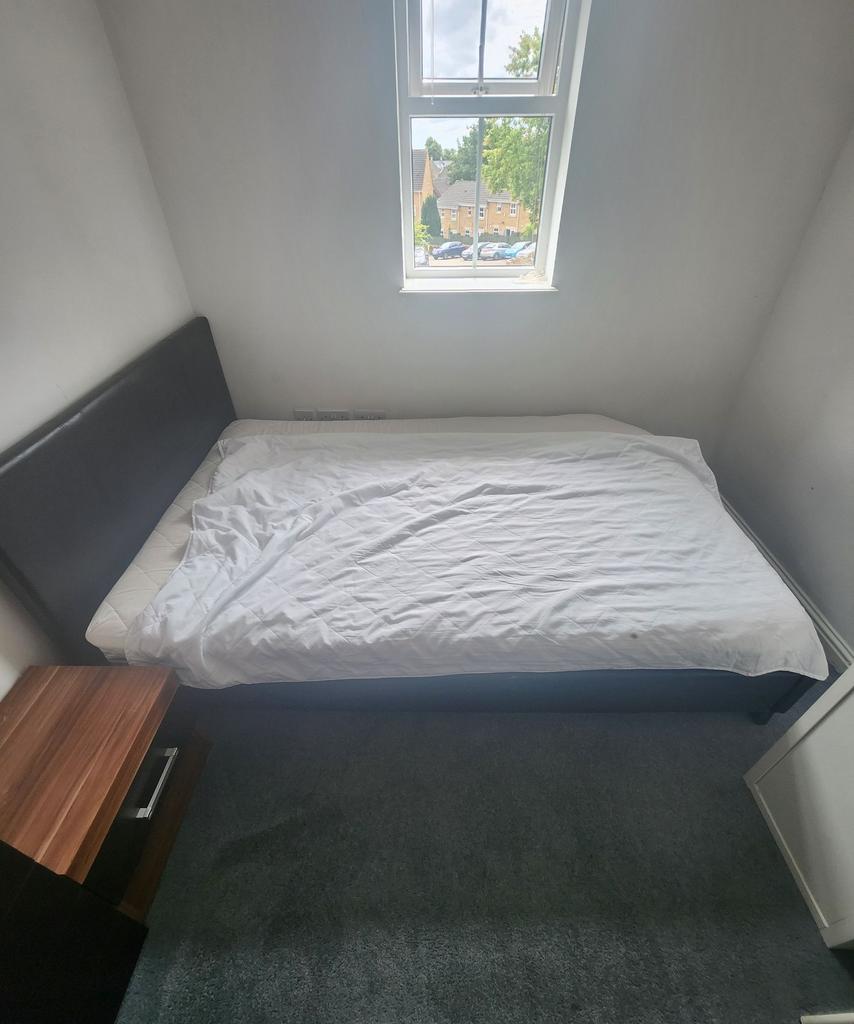 A cozy single bedroom featuring a neatly made b...