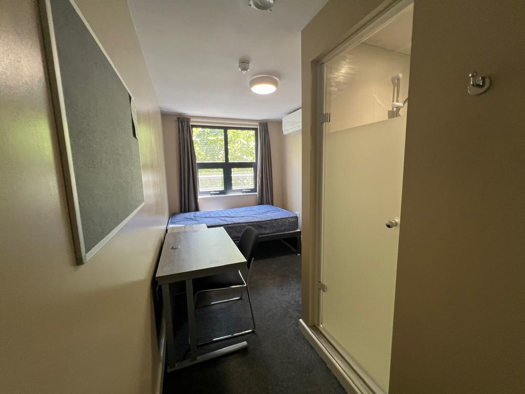 Neat single bedroom with a study desk and chair...