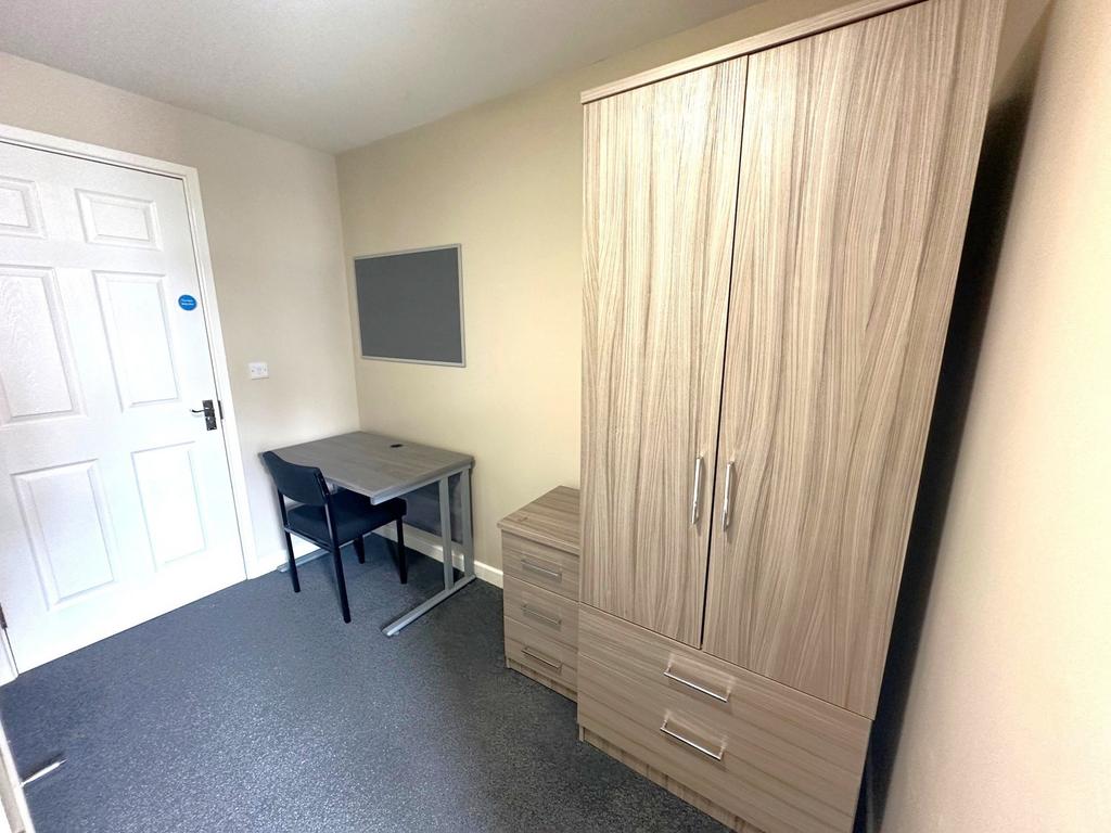 Neat furnished bedroom with a modern wood-look ...