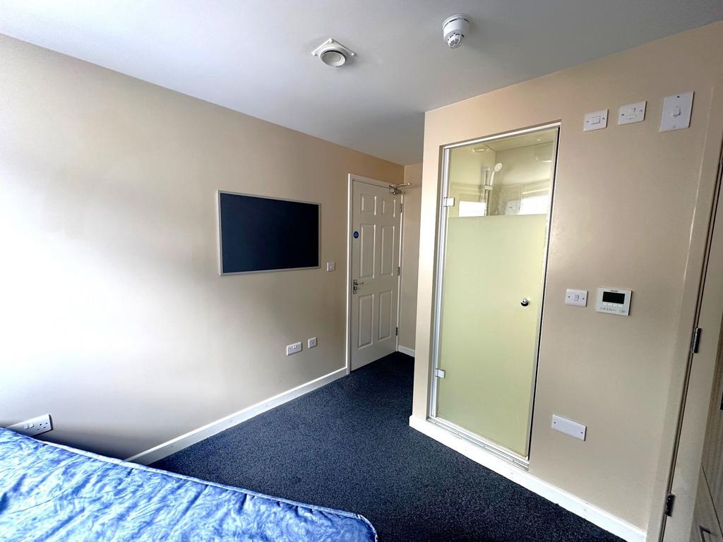 Neat single bedroom with wall-mounted TV panel,...