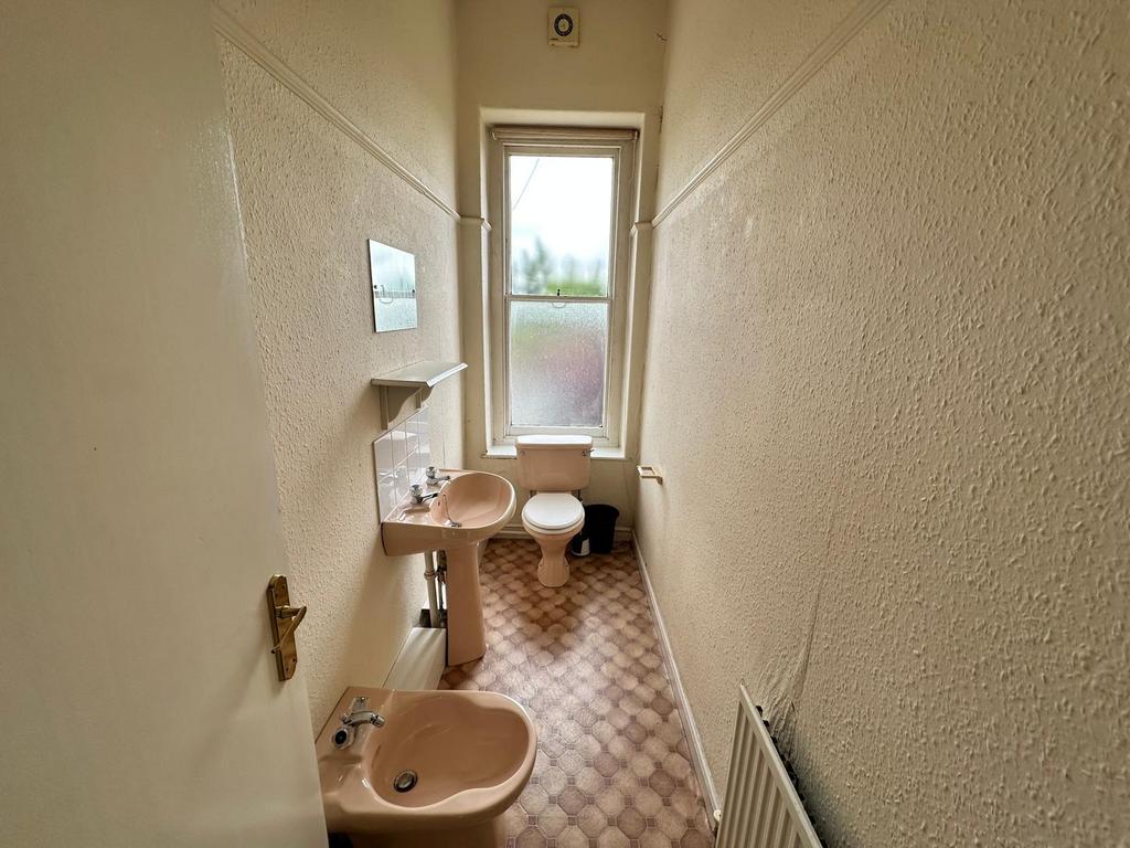 Narrow bathroom with matching pastel sanitarywa...