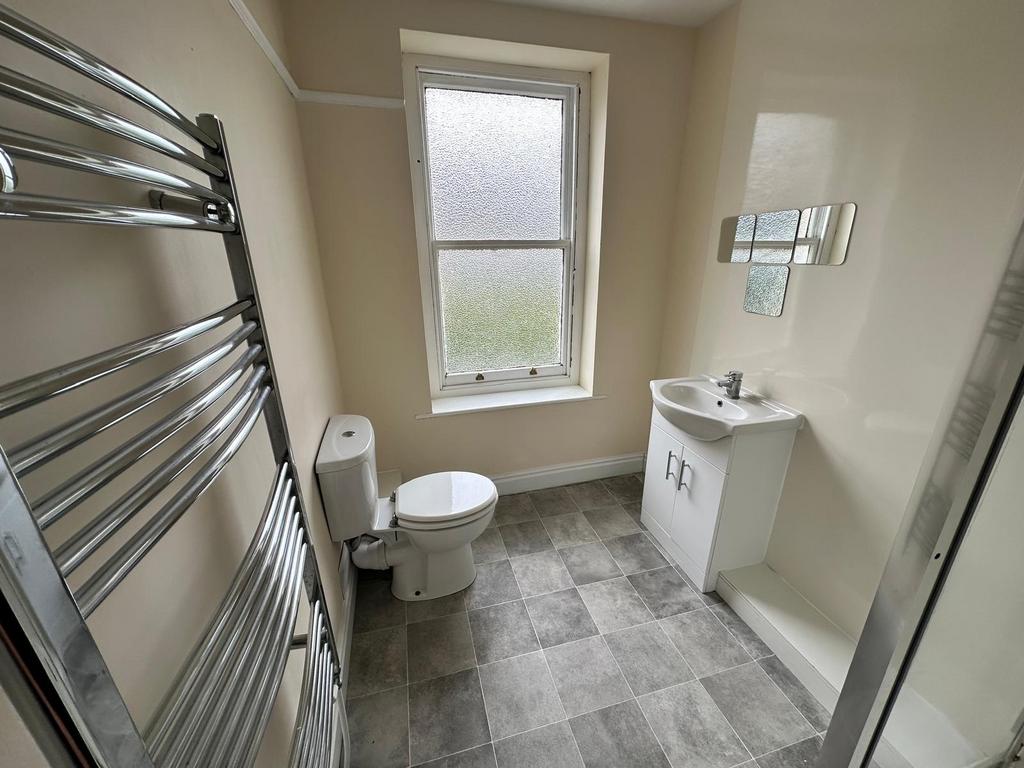 Bright, freshly painted bathroom with a frosted...