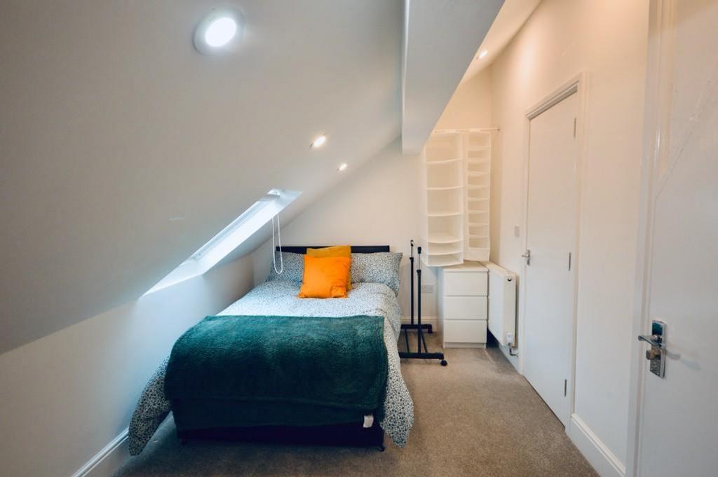 Bright and cozy single bedroom featuring a comf...