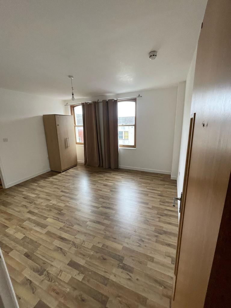 Spacious double bedroom featuring large windows...