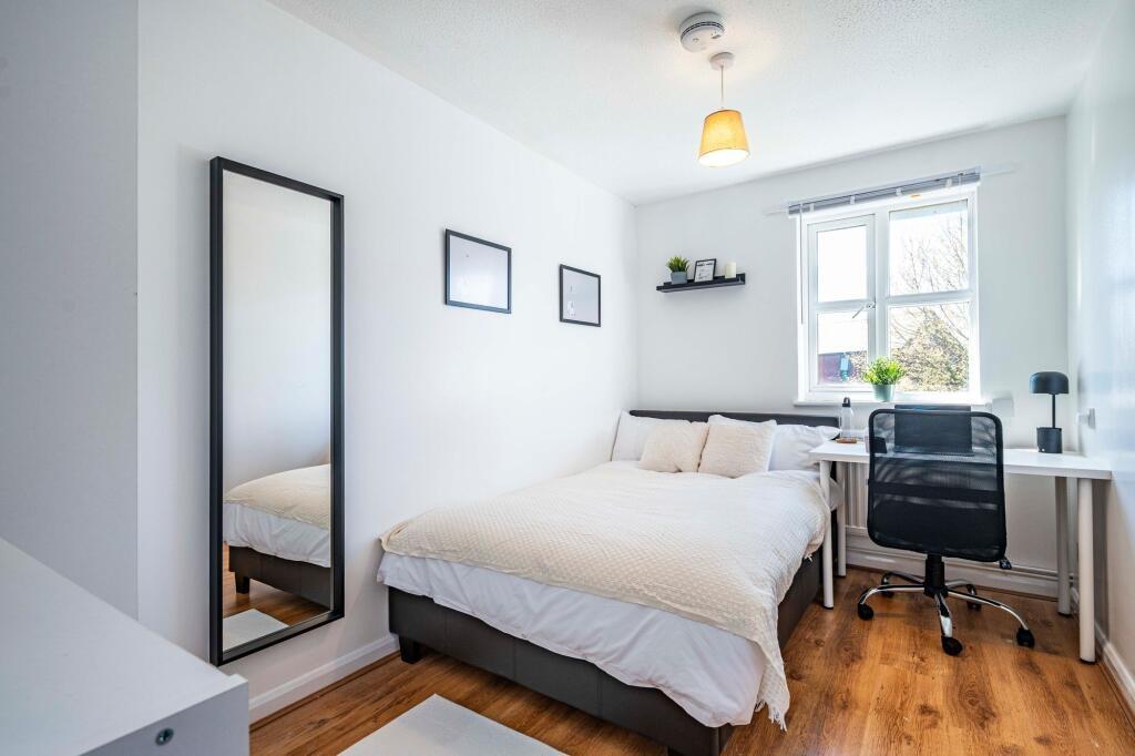 A bright and inviting bedroom featuring a comfo...