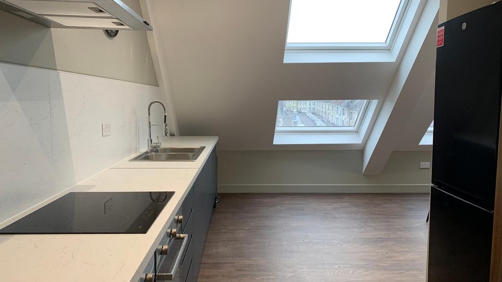 A modern and clean kitchenette with ample natur...