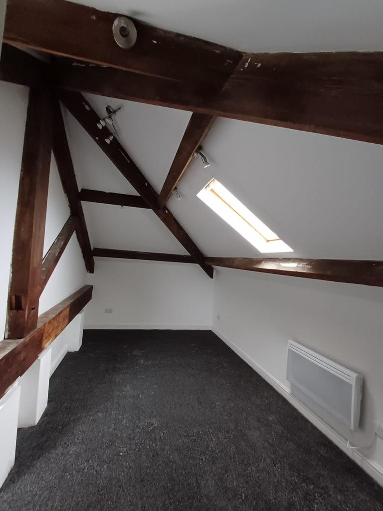 A charming double bedroom featuring exposed woo...