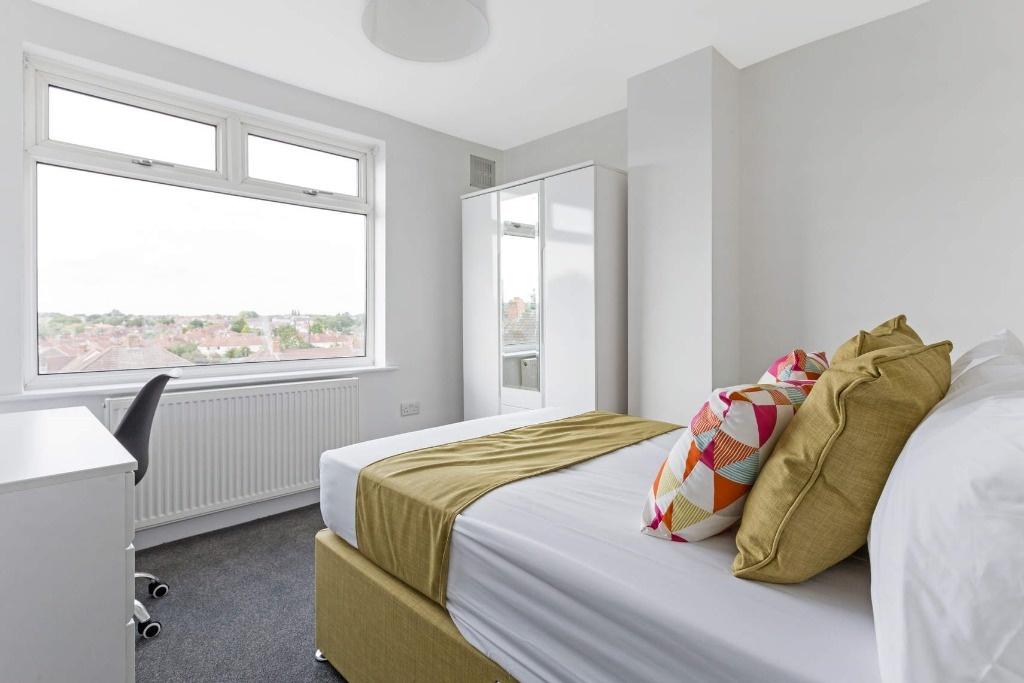 Bright, neatly presented bedroom with a large w...