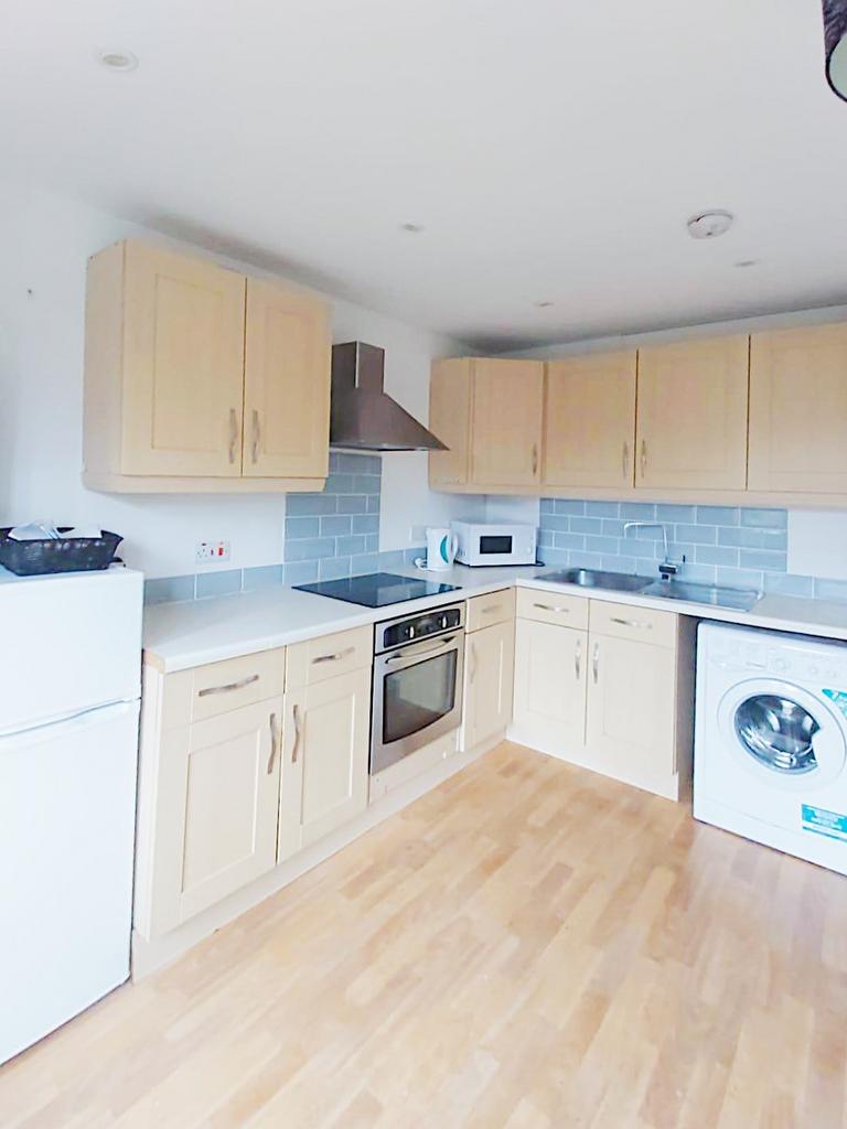 Bright, modern kitchen with light wood cabinets...