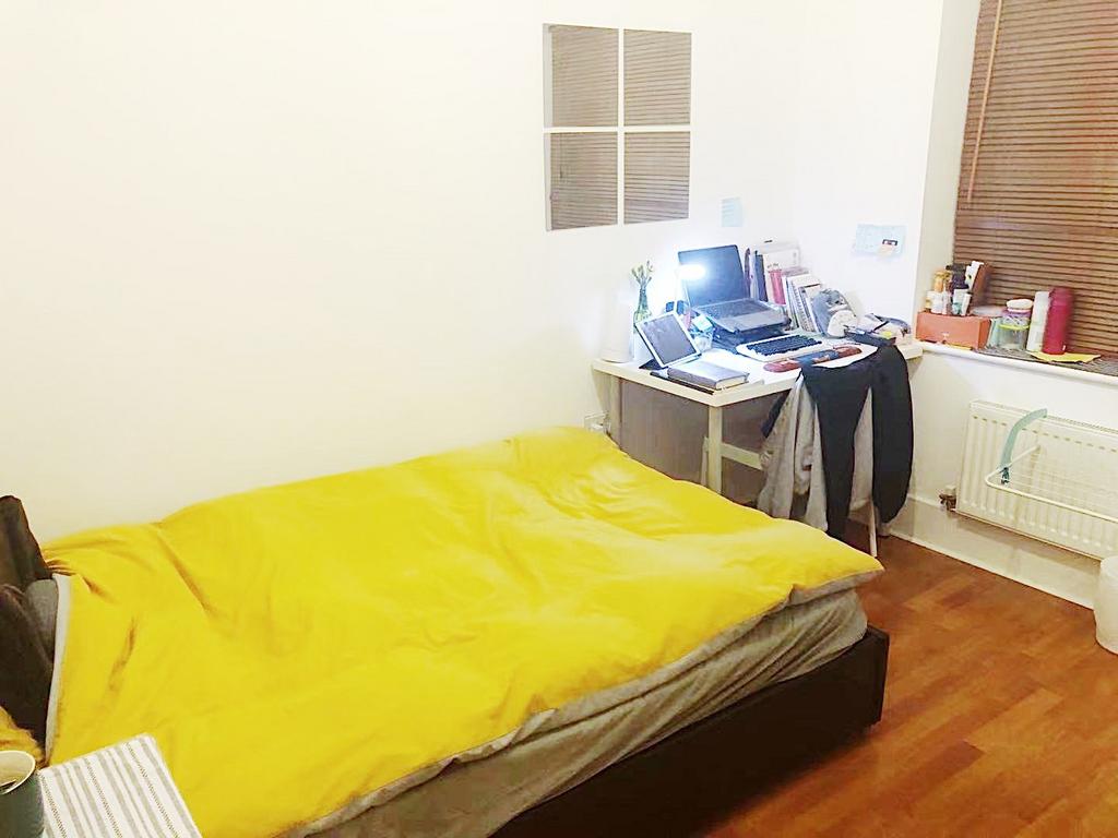 Bright, simply furnished bedroom with a double ...