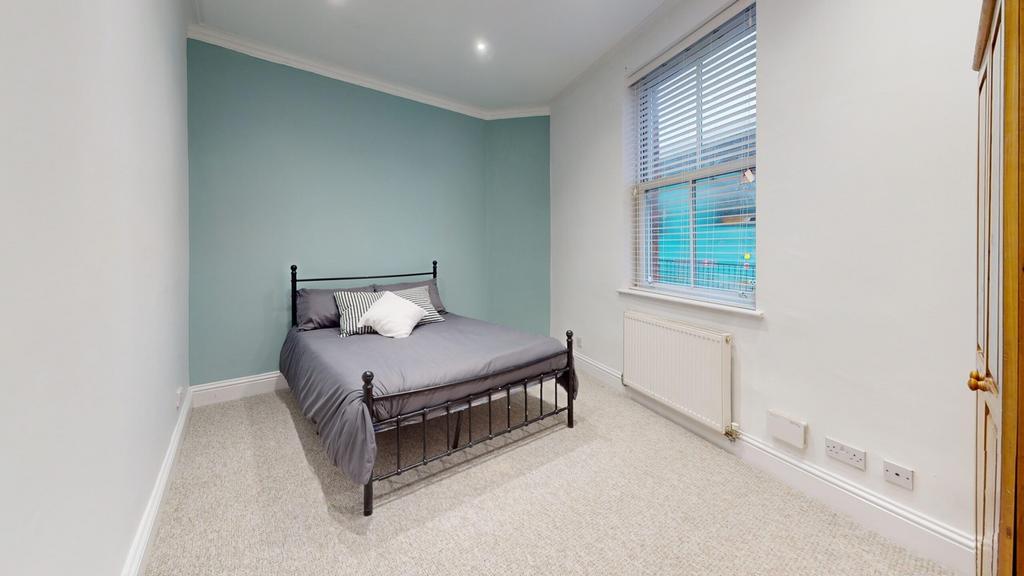 A bright and inviting double bedroom with a coz...