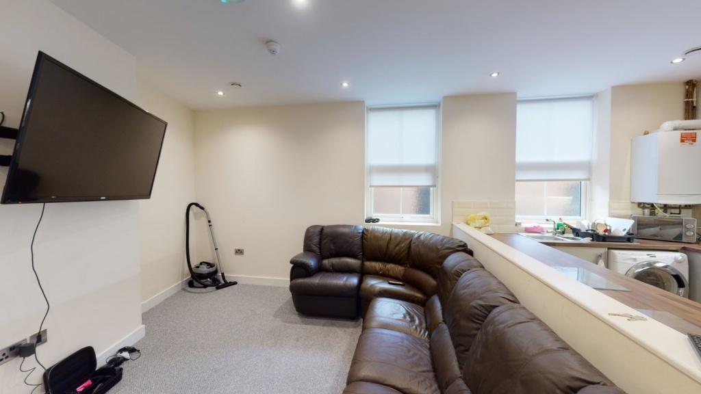 A cozy living room featuring a large brown leat...