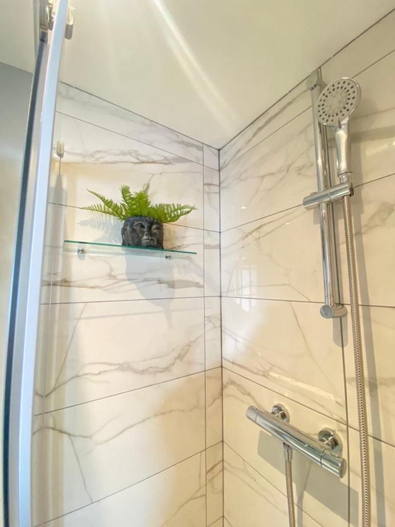A modern bathroom featuring a stylish shower wi...