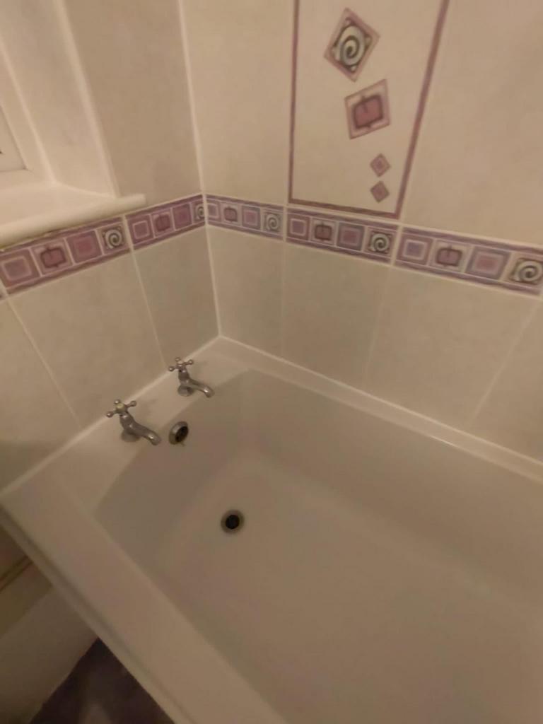 A well-maintained bathroom featuring a cozy bat...