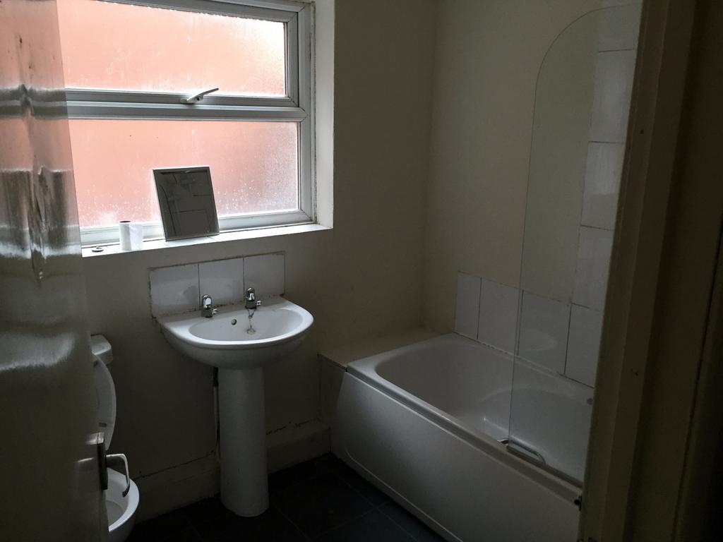 Bright and modern bathroom featuring a bath and...