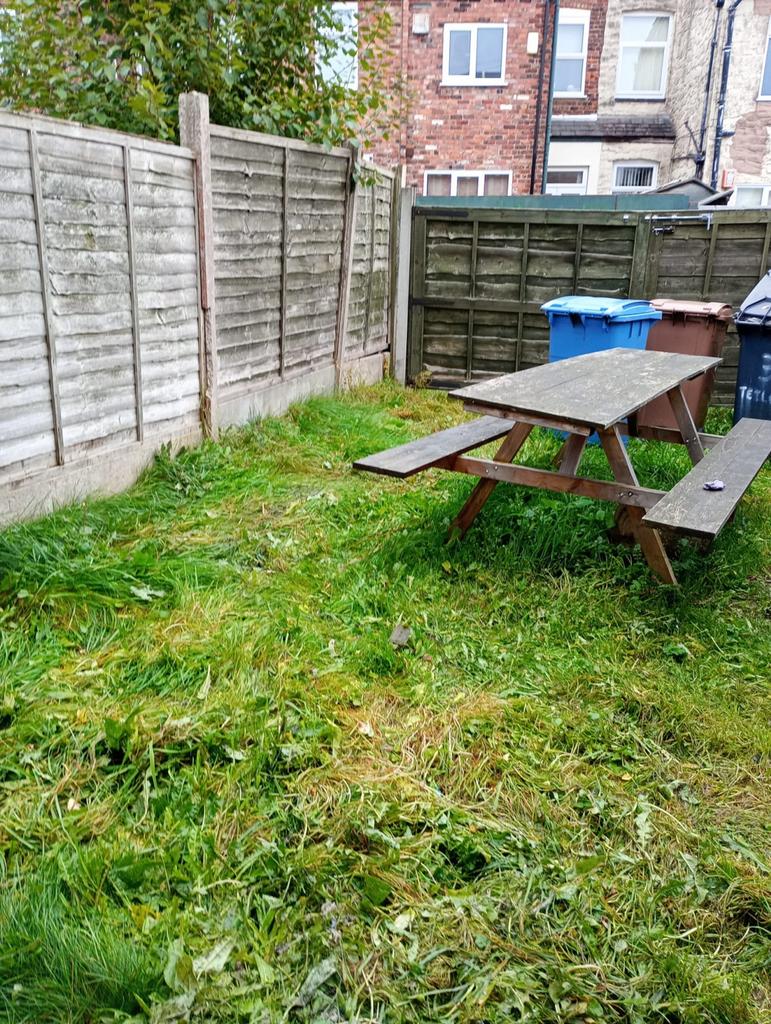 A charming garden space featuring a picnic tabl...