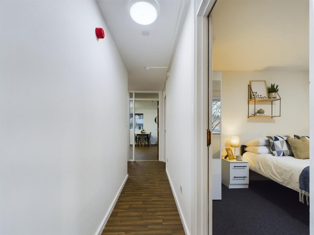 A well-maintained hallway leading to a cozy liv...