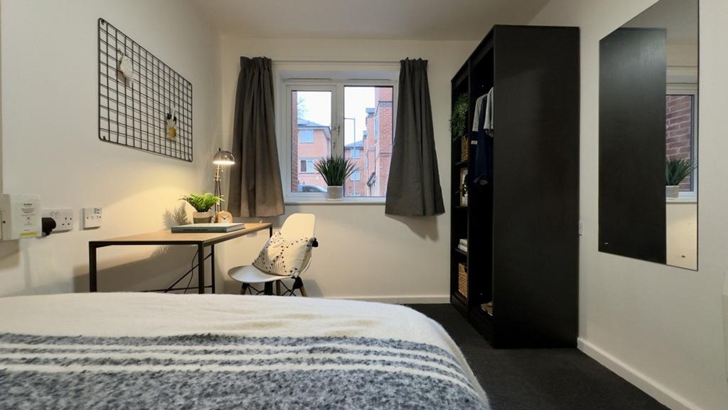 A bright and tidy double bedroom featuring a co...