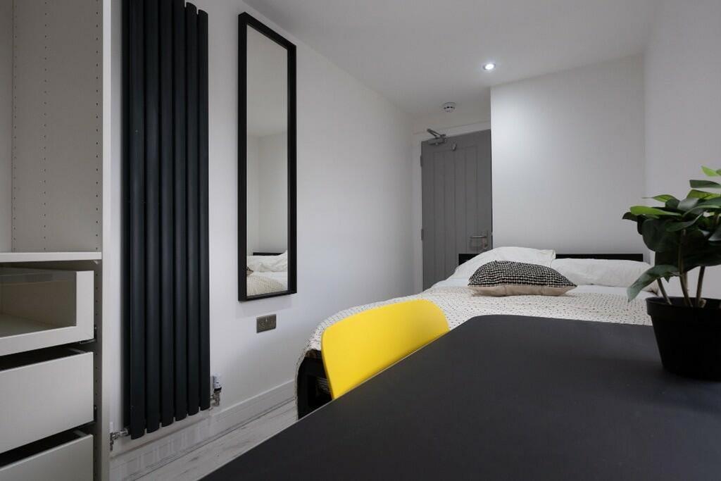 This inviting double bedroom features a comfort...
