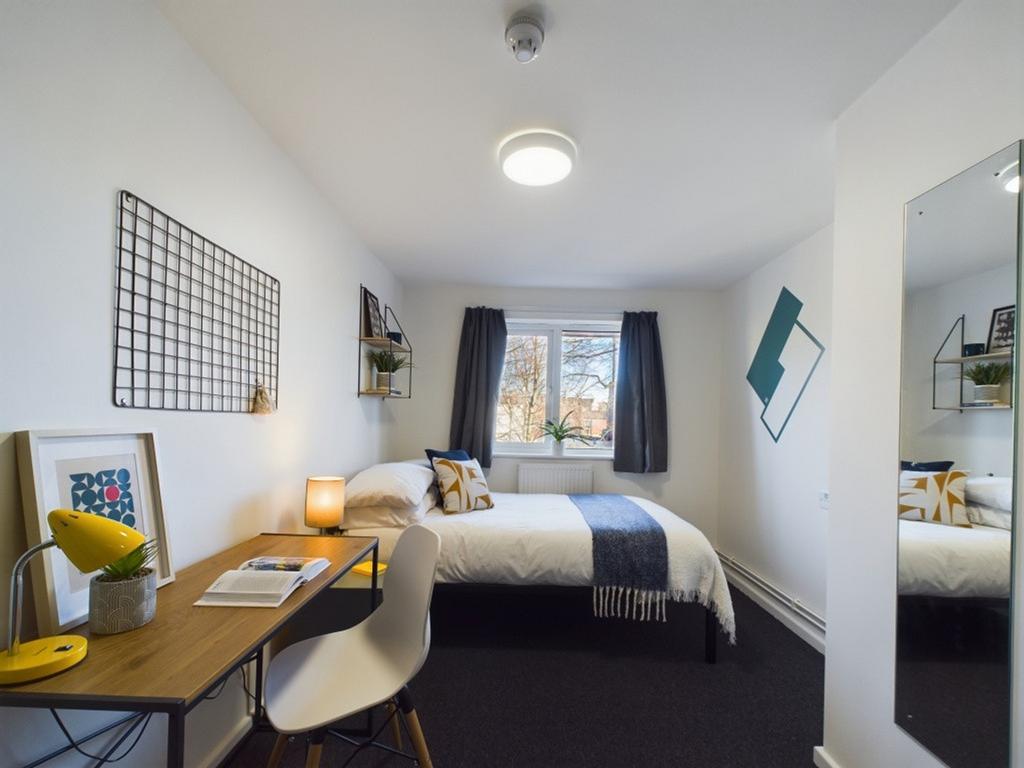 A bright and inviting double bedroom with a coz...