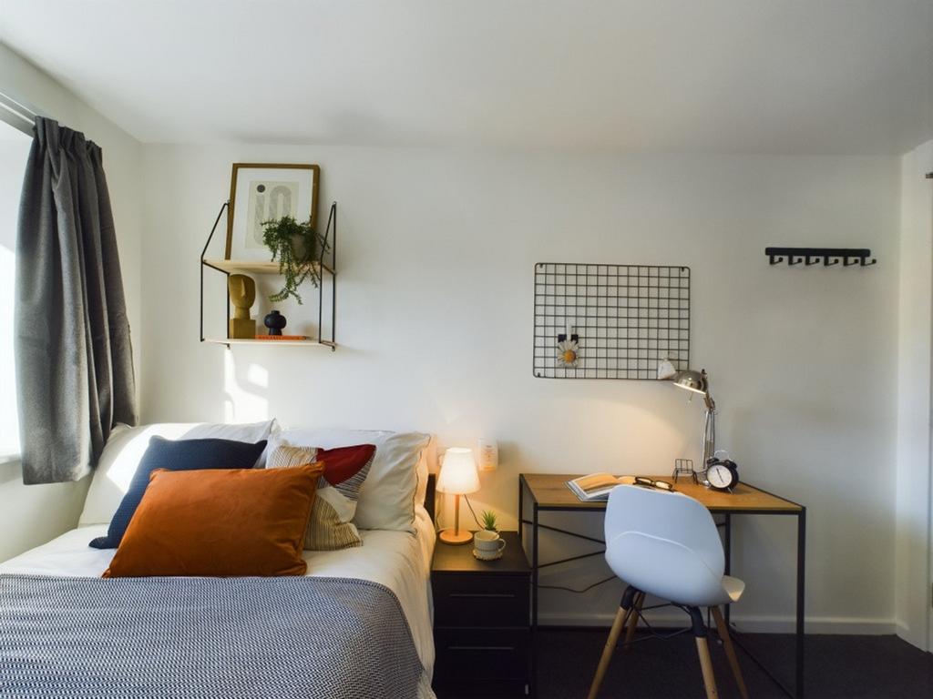 A bright and inviting double bedroom with a coz...