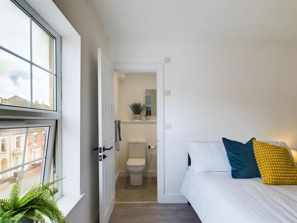 A bright and inviting double bedroom with a wel...