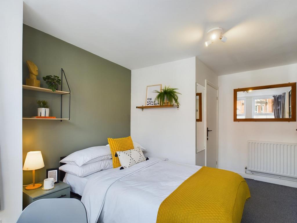 A bright and inviting bedroom featuring a comfo...