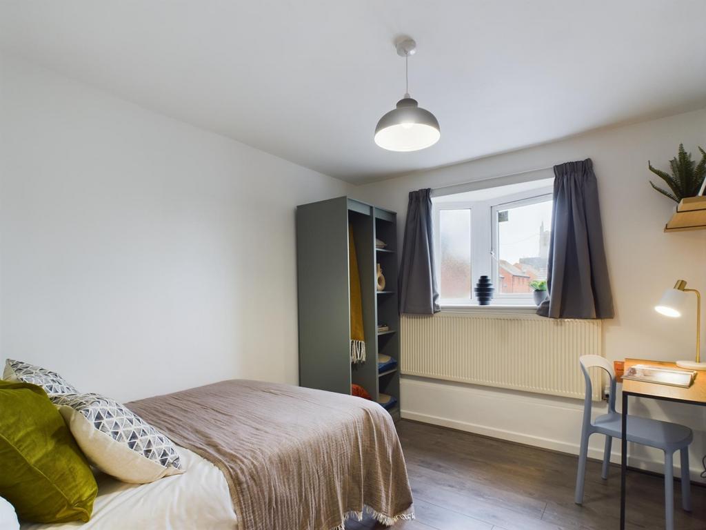 A bright and well-maintained bedroom featuring ...