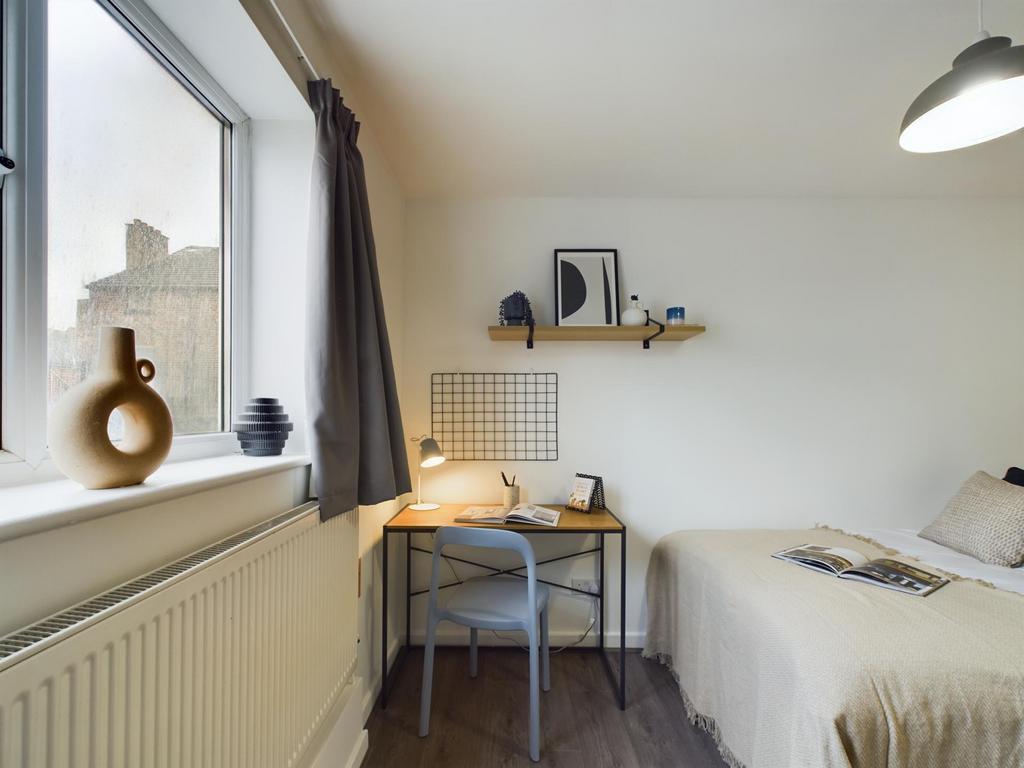 A cozy and well-maintained bedroom featuring a ...