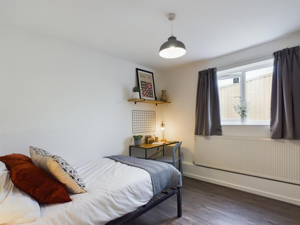 Bright and inviting bedroom featuring a cozy be...