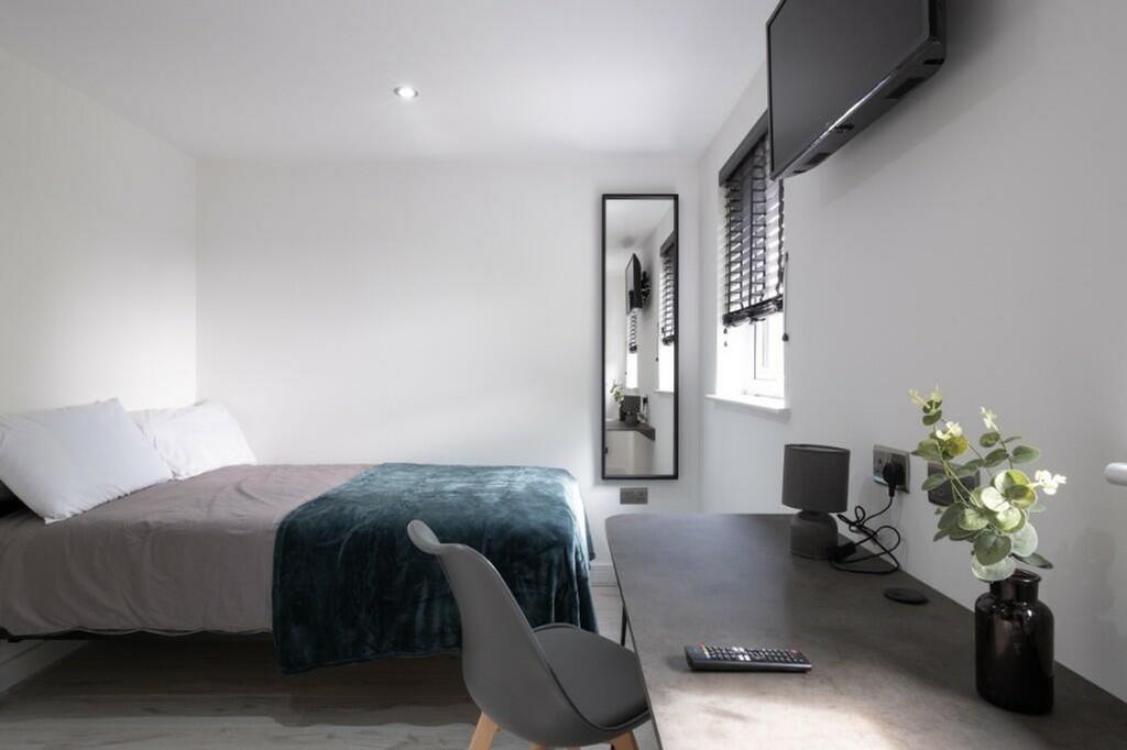A bright and inviting double bedroom with moder...