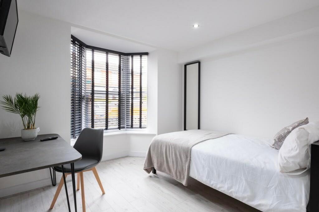 A bright and tidy single bedroom featuring a st...