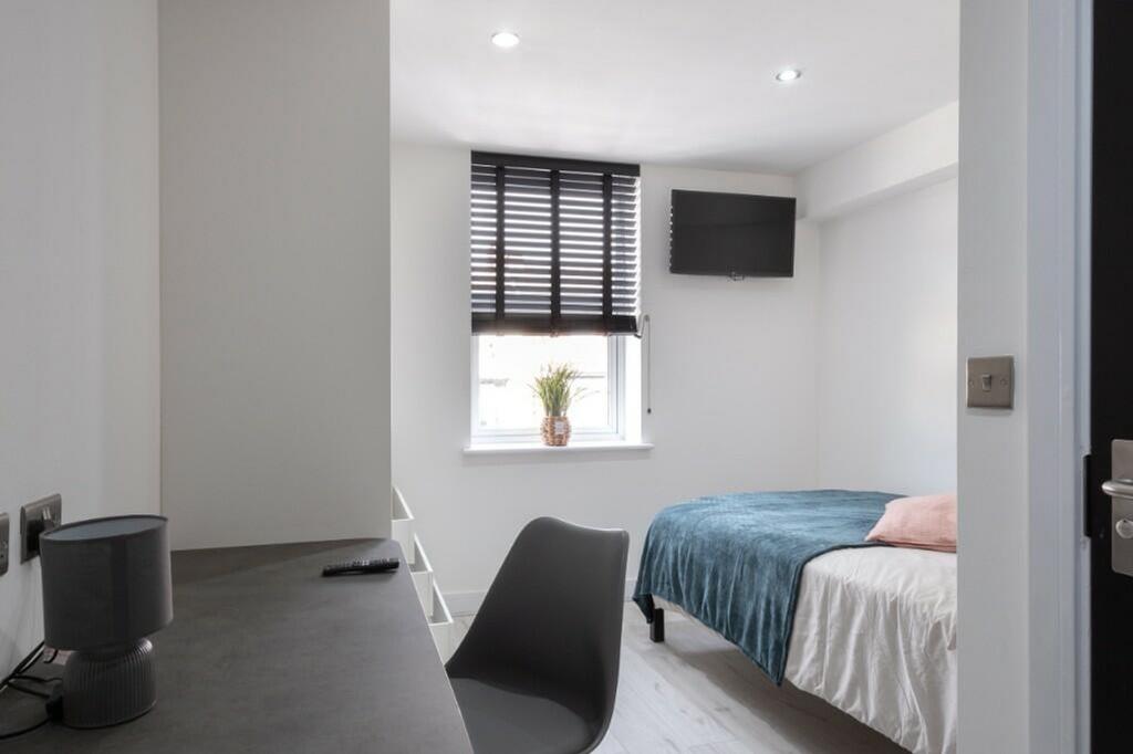 A bright and tidy double bedroom with modern de...